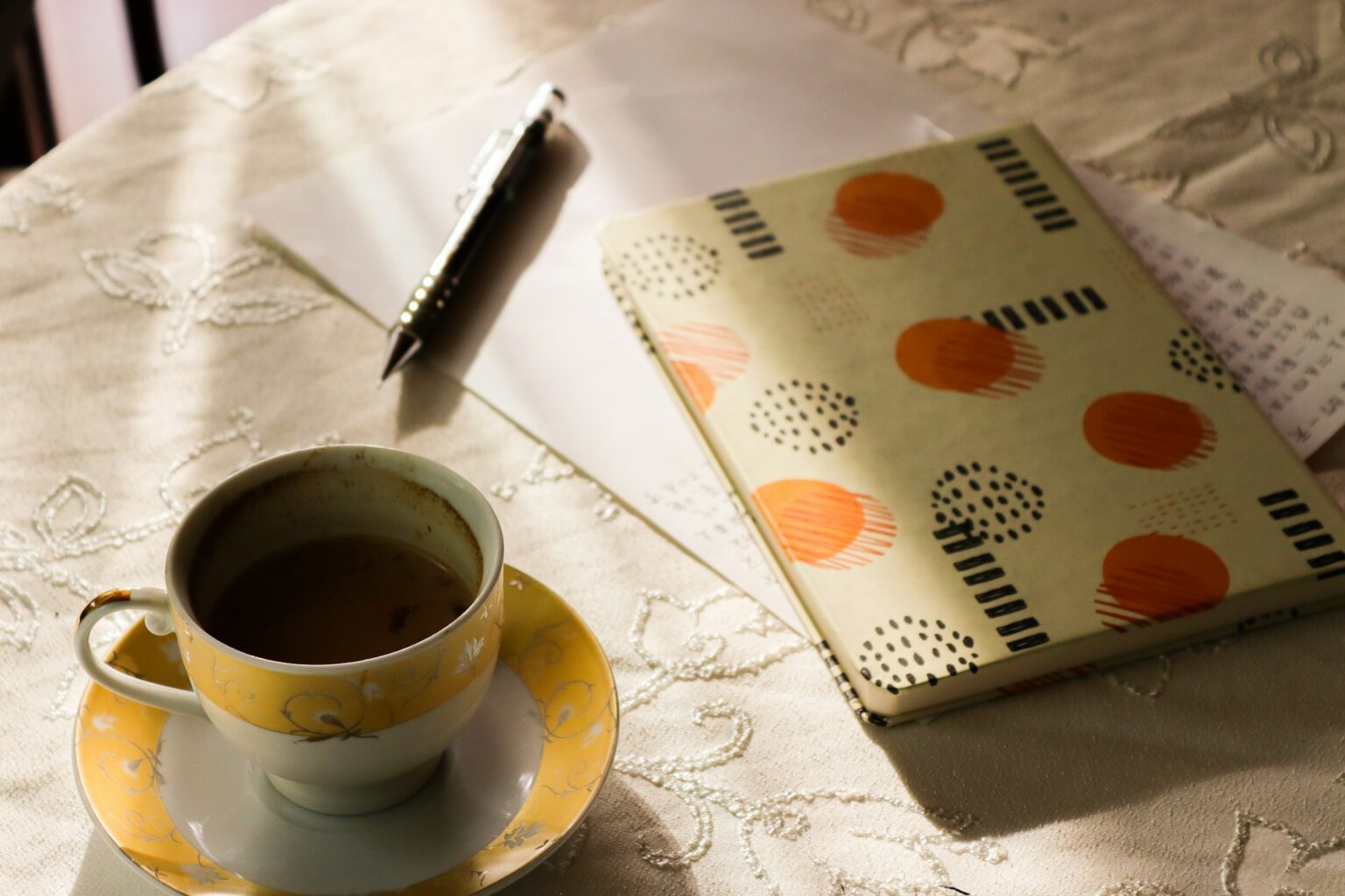 貿易実務検定A級の勉強に取り組むイメージ。机の上にコーヒとノートが置かれている。